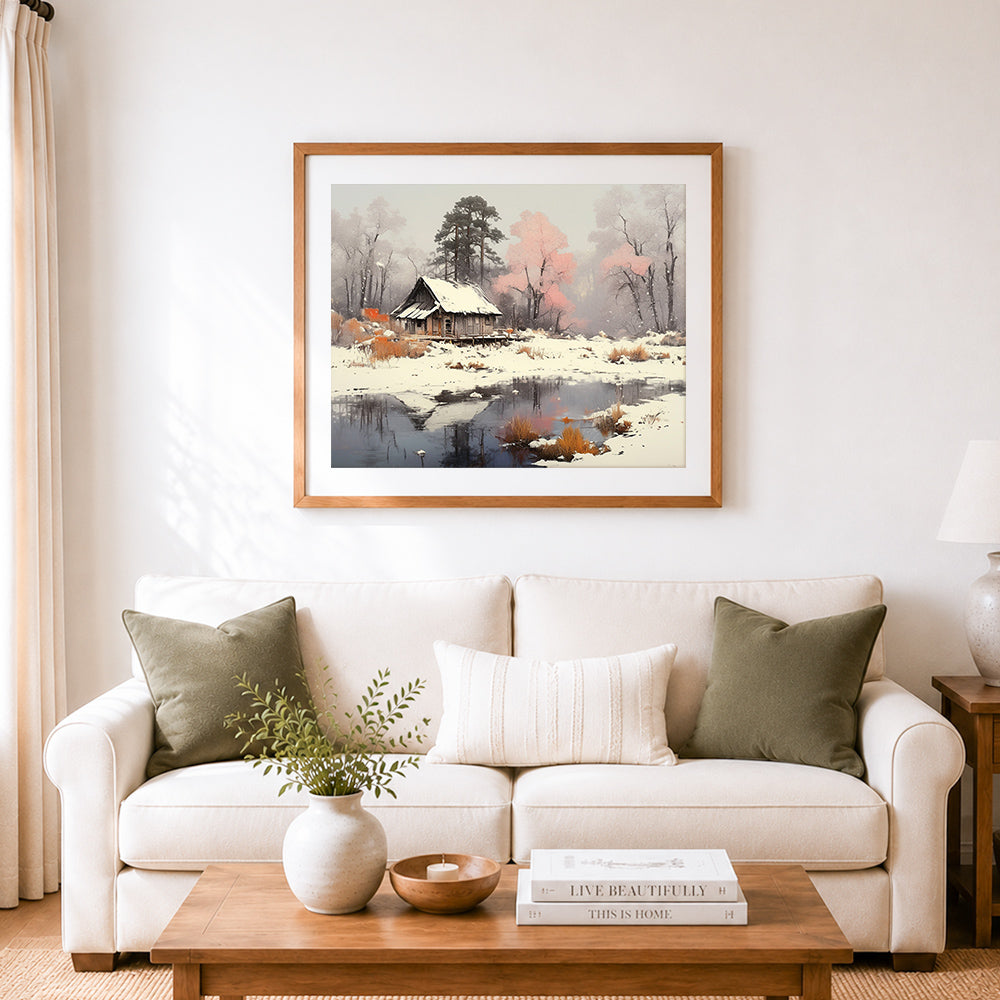 Finished snowy cabin with pink trees in winter mist cross stitch artwork displayed as home decor