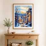 Finished snowy european town at sunset cross stitch artwork displayed as home decor
