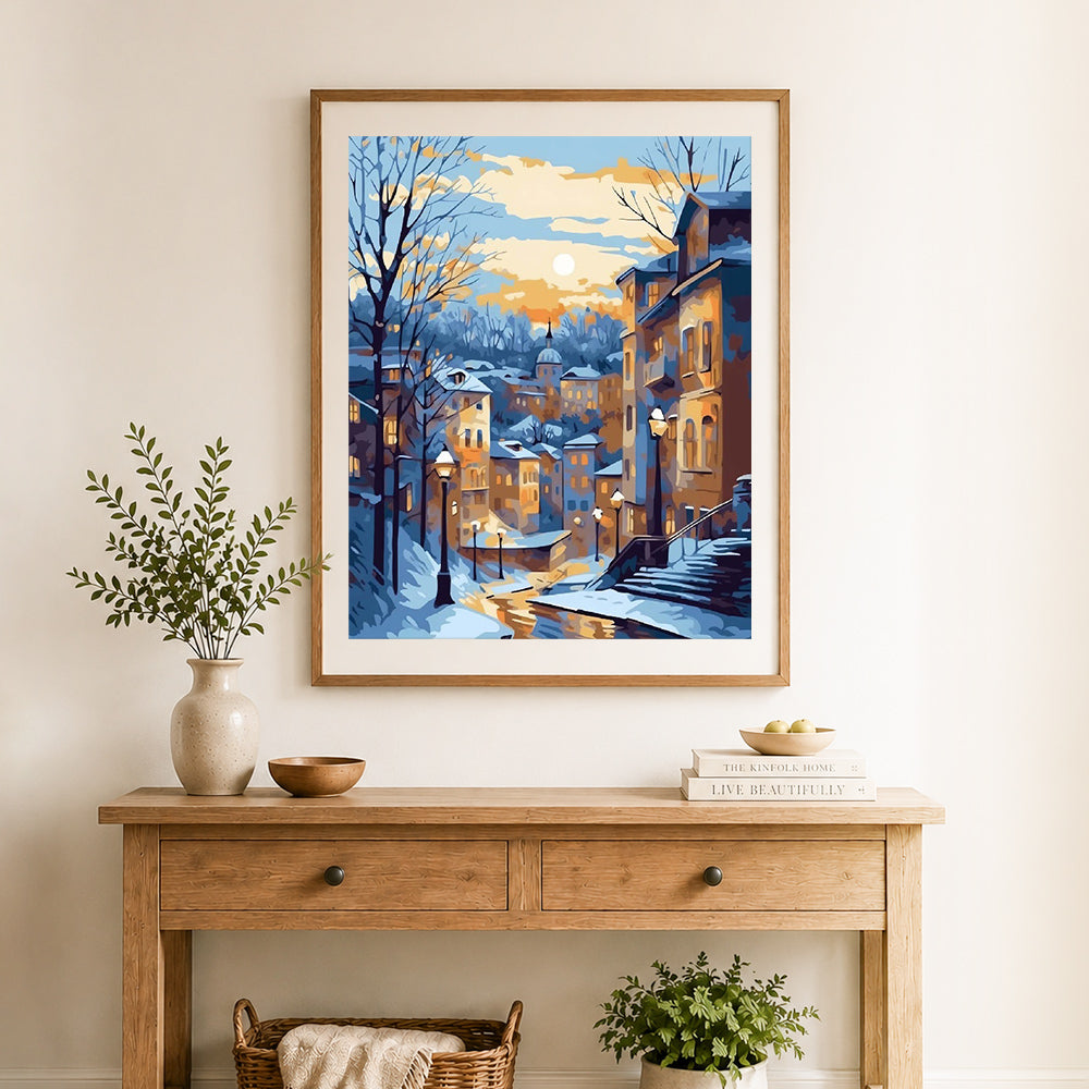 Finished snowy european town at sunset cross stitch artwork displayed as home decor