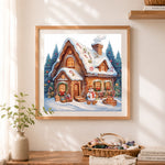 Finished snowy gingerbread house cross stitch artwork displayed as home decor