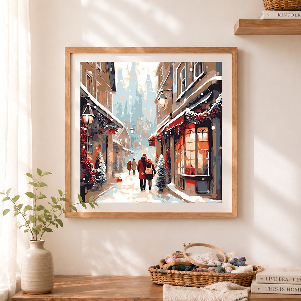 Finished snowy holiday street walk cross stitch artwork displayed as home decor