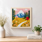 Finished snowy mountain and wildflowers artwork displayed on a wall