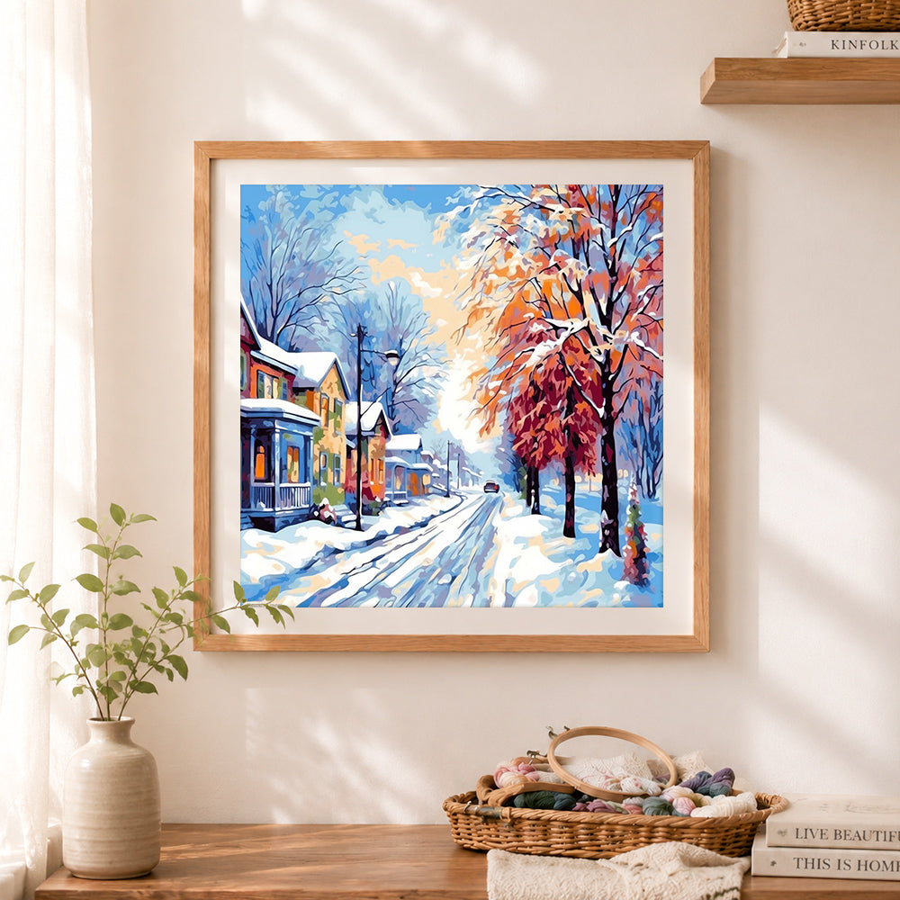 Finished snowy small town neighborhood street cross stitch artwork displayed as home decor