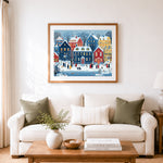 Finished snowy town street scene with people walking cross stitch artwork displayed as home decor
