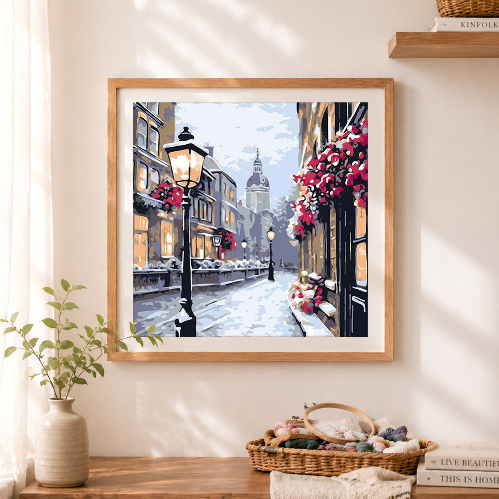 Finished snowy vintage european street cross stitch artwork displayed as home decor