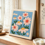 Soft daisies punch needle artwork displayed on a table