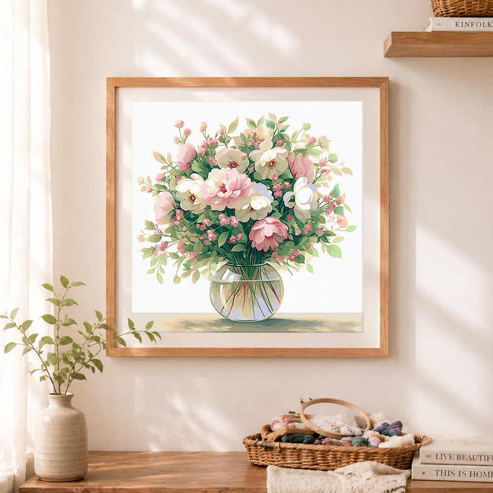 Finished soft pink and white floral bouquet in glass vase cross stitch artwork displayed as home decor