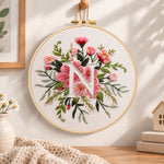 Soft pink petals and letter n embroidery hoop wall art displayed as warm and cozy handmade home decor