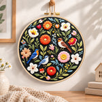 Songbirds and vibrant blooms embroidery hoop wall art displayed as warm and cozy handmade home decor
