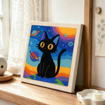 Space black cat with yellow eyes punch needle artwork displayed on a table