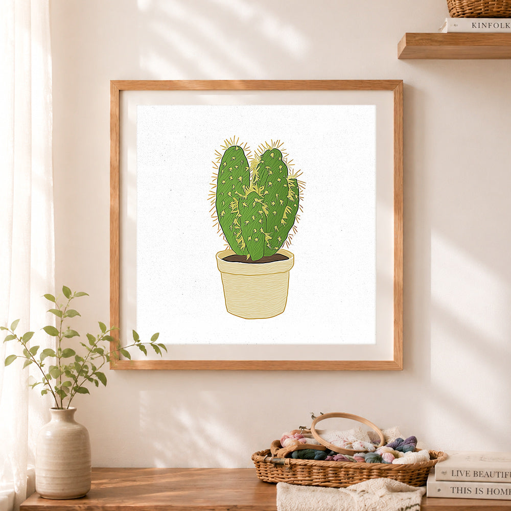 Finished spiky potted cactus cross stitch artwork displayed as home decor