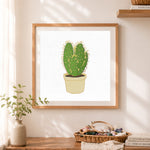 Finished spiky potted cactus cross stitch artwork displayed as home decor