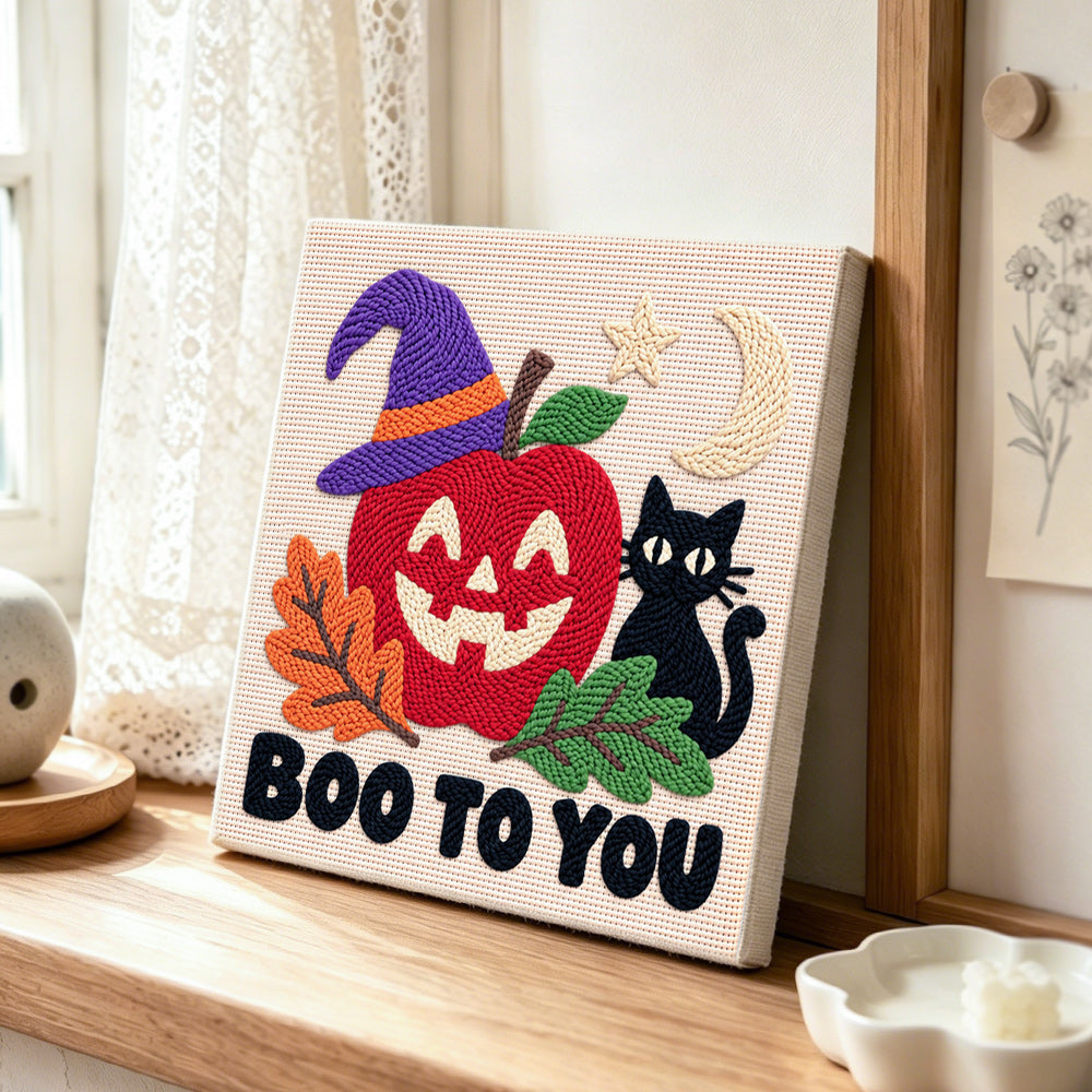 Spooky apple face punch needle artwork displayed on a table