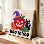 Spooky apple face punch needle artwork displayed on a table
