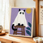 Spooky ghost cat on stool punch needle artwork displayed on a table