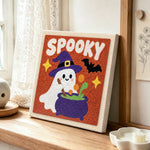 Spooky ghost with cauldron punch needle artwork displayed on a table