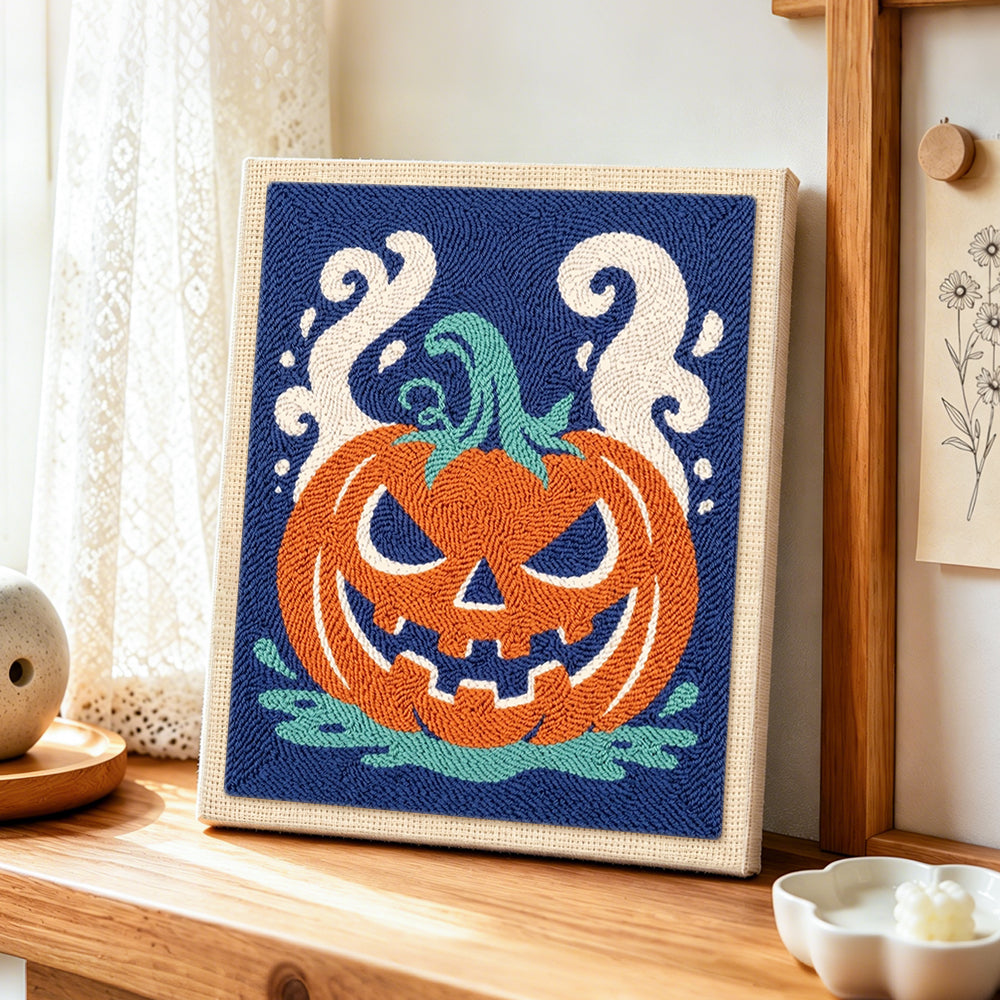 Spooky jack‑o‑lantern punch needle artwork displayed on a table