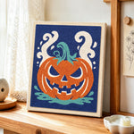 Spooky jack‑o‑lantern punch needle artwork displayed on a table