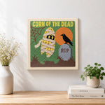 Finished spooky mummy corn artwork displayed on a wall