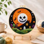 Finished spooky skeleton face moon needle felting displayed on a wooden easel