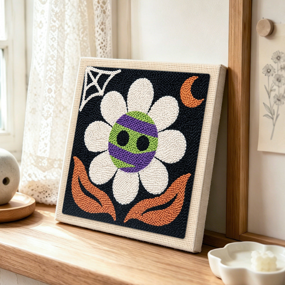 Spooky striped flower punch needle artwork displayed on a table