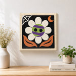Finished spooky striped flower artwork displayed on a wall