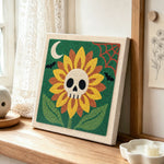 spooky sunflower with skull center punch needle artwork displayed on a table