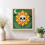 Finished spooky sunflower with skull center artwork displayed on a wall