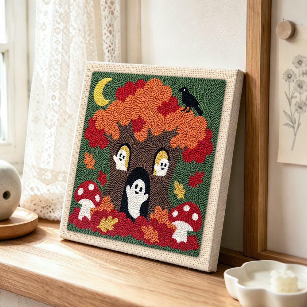 Spooky tree with little ghosts punch needle artwork displayed on a table