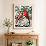 Finished spring cardinals on white picket fence cross stitch artwork displayed as home decor