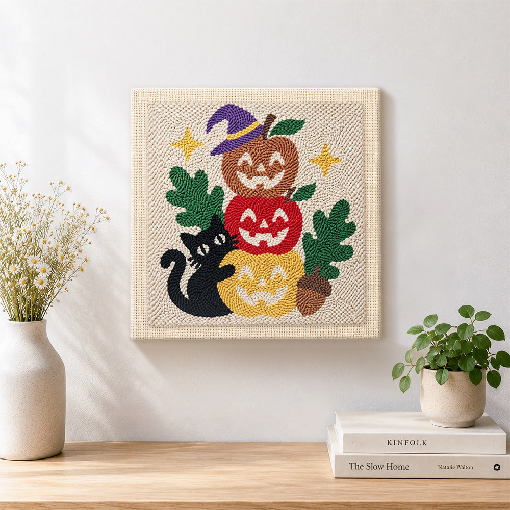 Finished stacked pumpkins with black cat artwork displayed on a wall