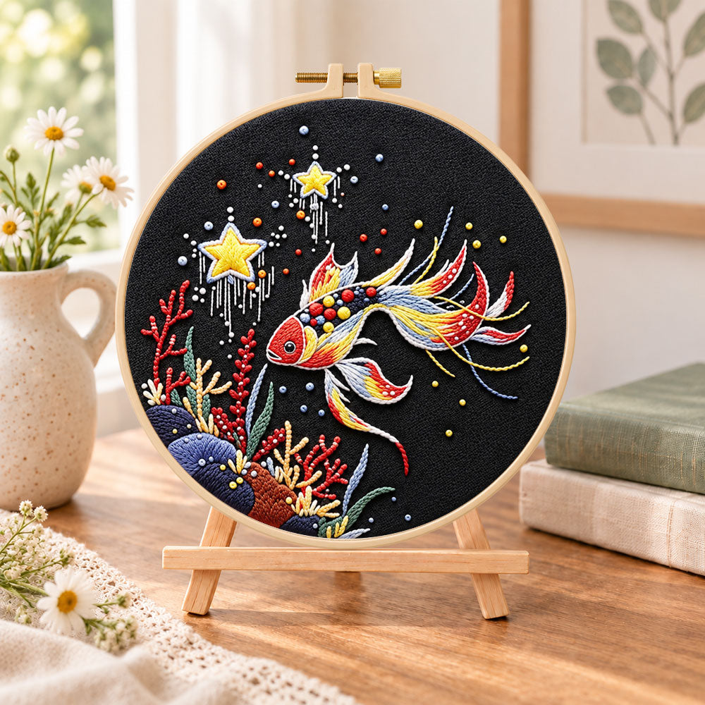 Star and coral koi embroidery kit finished hoop displayed on a wooden stand as cozy tabletop decor
