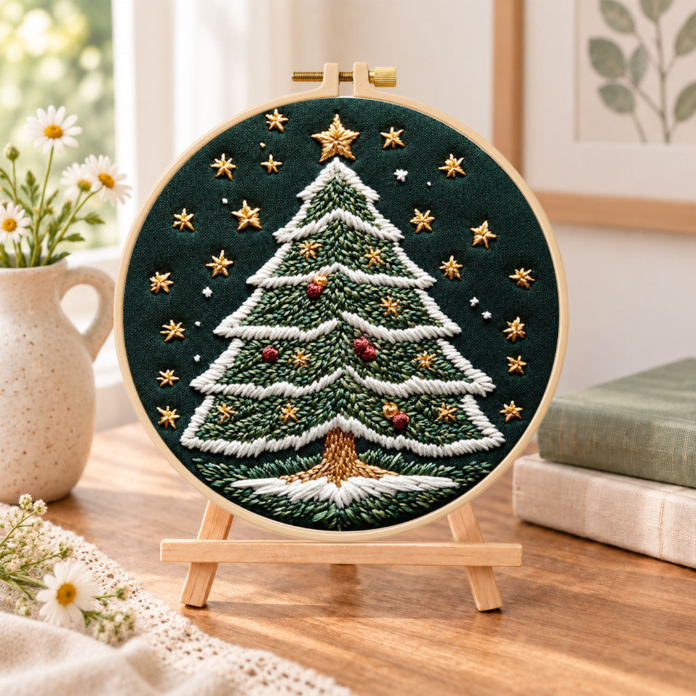 Starry christmas tree embroidery kit finished hoop displayed on a wooden stand as cozy tabletop decor