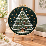 Starry christmas tree embroidery kit finished hoop displayed on a wooden stand as cozy tabletop decor