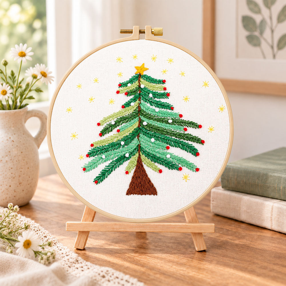 Starry christmas tree with stars embroidery kit finished hoop displayed on a wooden stand as cozy tabletop decor
