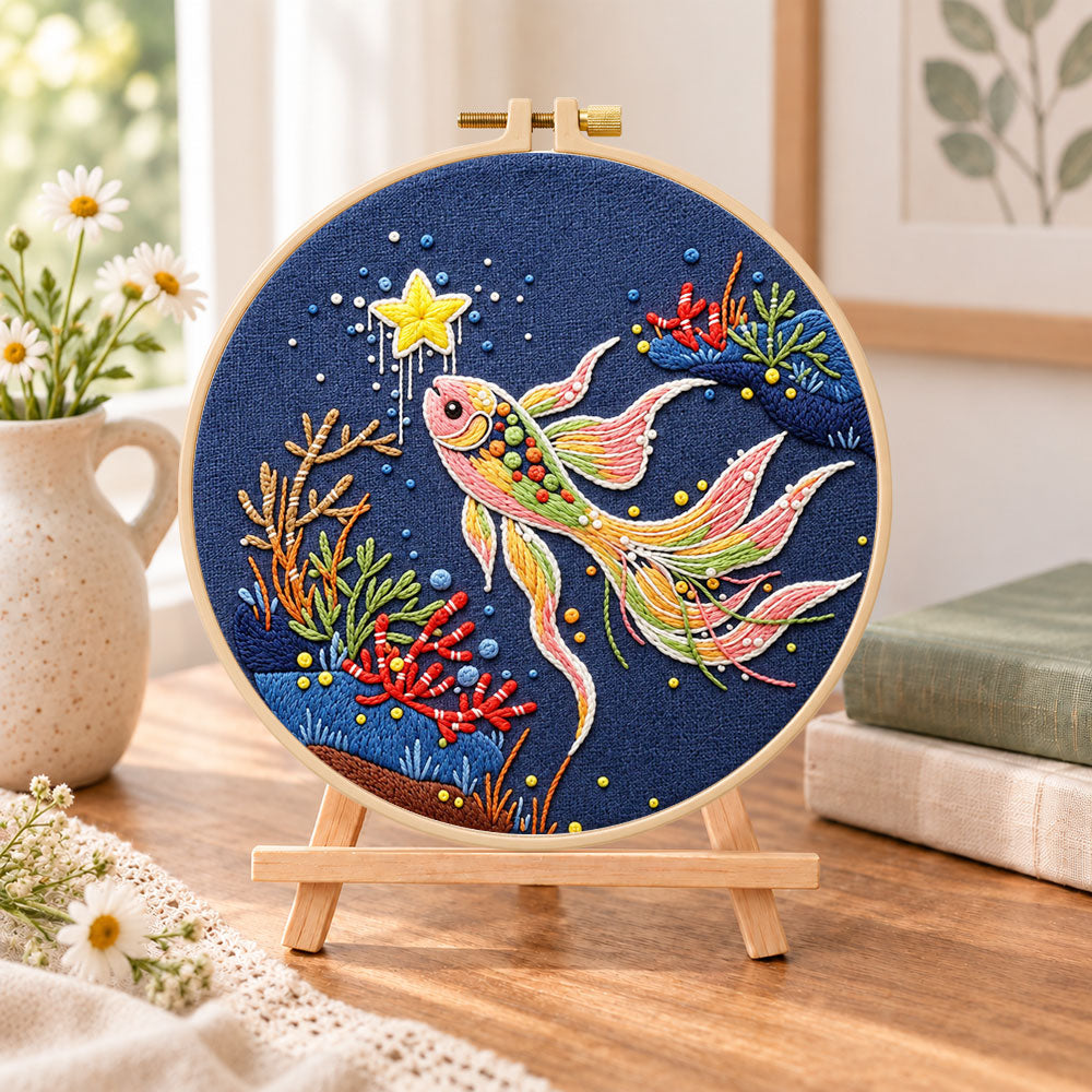 Starry koi fish embroidery kit finished hoop displayed on a wooden stand as cozy tabletop decor