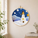 Starry night snowy lighthouse needle felt wall art displayed in a bright home interior