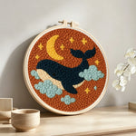 Starry whale punch needle artwork displayed on a table