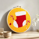 Stocking and candy canes punch needle artwork displayed on a table