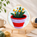 Finished striped pot with yellow flowers needle felting displayed on a wooden easel