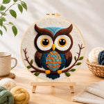 Finished stylish blue and orange owl needle felting displayed on a wooden easel