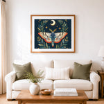 Finished stylized moth with crescent moon and stars cross stitch artwork displayed as home decor