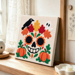Sugar skull with fall foliage punch needle artwork displayed on a table