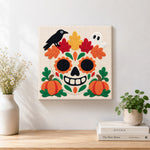 Finished sugar skull with fall foliage artwork displayed on a wall