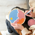 Creating handmade sun over colorful clouds punch needle artwork