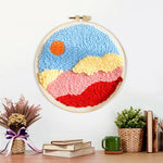 Finished sun over colorful mountains and clouds artwork displayed on a wall