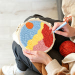 Creating handmade sun over colorful mountains punch needle artwork