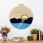 Finished sun over mountains and water artwork displayed on a wall