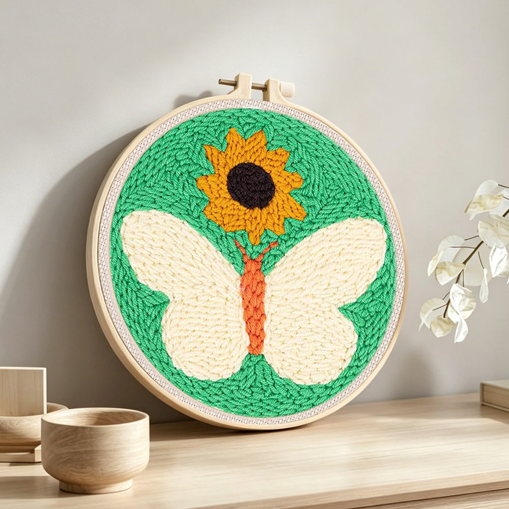 Sunflower and white butterfly punch needle artwork displayed on a table