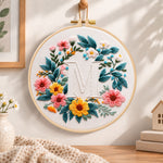 Sunny floral wreath and letter m embroidery hoop wall art displayed as warm and cozy handmade home decor